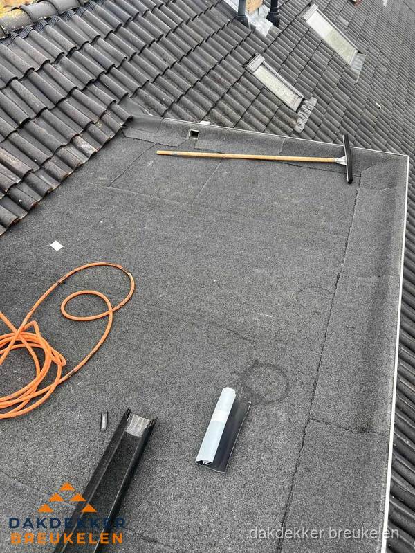 Plat dak reparatie met gereedschap en loodstroken in Breukelen