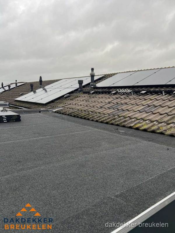 Bitumen dakbedekking op plat dak met aansluitend pannendak en zonnepanelen in Breukelen