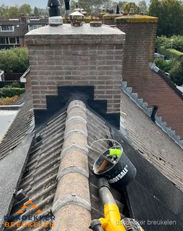 Schoorsteen met loodaansluiting en nokvorst op pannendak in Breukelen