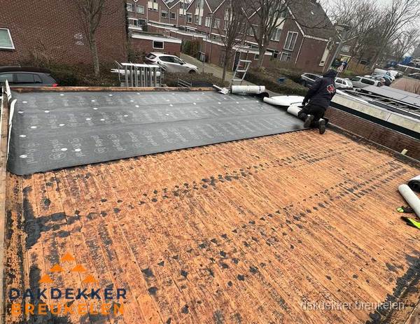 Dakdekker legt onderlaag op plat dak met houten constructie in Breukelen
