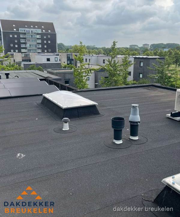 Groot plat dak met lichtkoepel en dakdoorvoeren in Breukelen