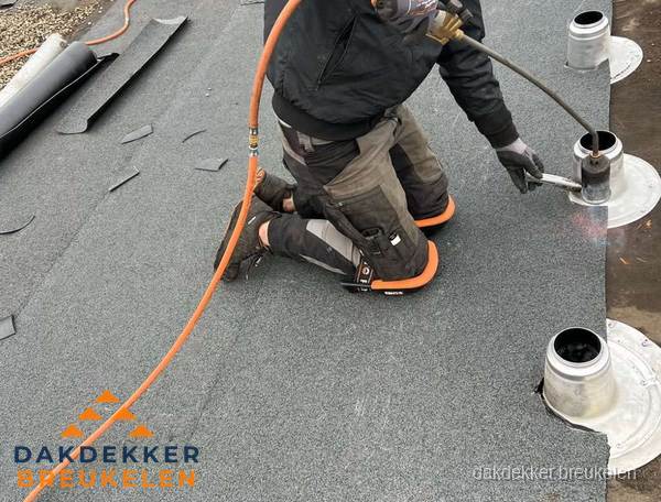 Dakdekker repareert bitumen dakleer bij dakdoorvoer in Breukelen
