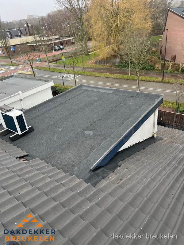 Plat dak met bitumen dakbedekking naast schuin pannendak in Breukelen
