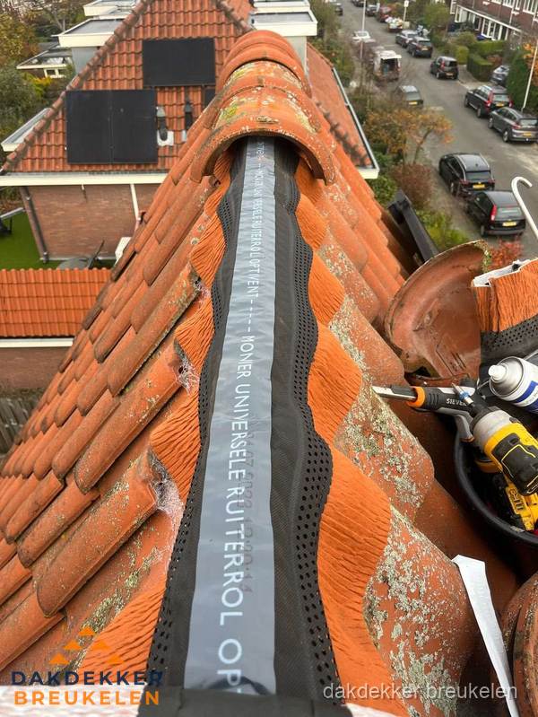 Dakdekker vervangt nokvorst met ruiterrol op pannendak in Breukelen