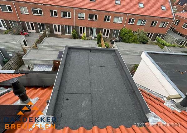 Plat dak met bitumen bedekking naast dakkapel in Breukelen